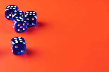 Blue dice on red background close up