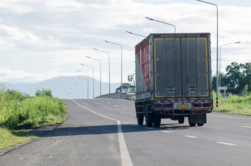 Commercial trailer truck in motion on Thailand freeway, cargo transportation.