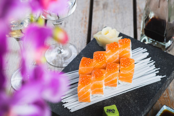 Traditional rolls with fish and rice on a white plate with sauce and wasabi. Japanese food.