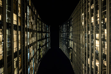 Modern tall long skyscrapers, going to the sky, as if to infinity. Night, Tel Aviv, Israel. View from below. Horizontal view. Close-up. Copy space.