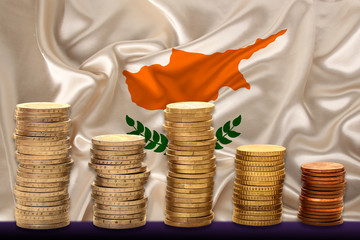 metal currency coins on the background of the national flag of the country of Cyprus, the concept...