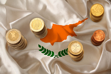 metal currency coins on the background of the national flag of the country of Cyprus, the concept...