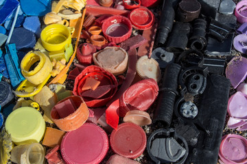 close-up of plastic trash spilled on the beach, dirty sea sandy shore, environmental pollution, ecological problem, aerial view of plastic garbage on the beach