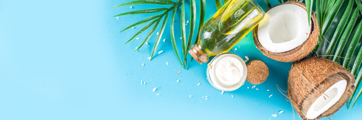 Coconut oil in glass jar with  tropical leaves and fresh coconut. Organic mct oils concept....
