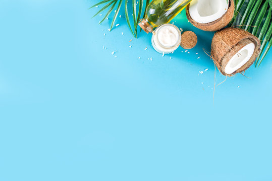 Coconut oil in glass jar with  tropical leaves and fresh coconut. Organic mct oils concept. turquoise, aquamarine background