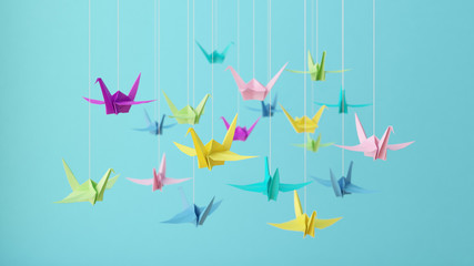 3D illustration-Colorful pastel origami paper cranes on blue background.