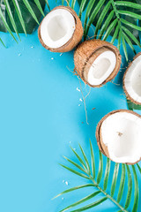 Fototapeta na wymiar Tropical summer background with tropical palm leaves and coconuts, trendy turquoise, aquamarine background flatlay copy space