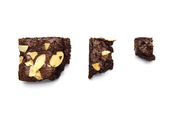Chocolate brownies with sliced almond nuts toppings broken isolated on white background.