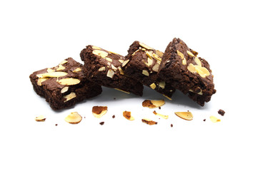 Pile of chocolate brownies with sliced almond nuts toppings broken and crumbs isolated on white...