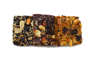 Homemade bread and bakery brownie, cake topped with groundnuts raisins sun flower seeds white and black sesame seeds isolated on white background. Top view photograph.