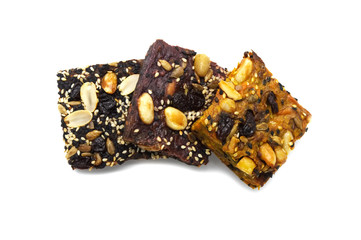Homemade bread and bakery brownie, cake topped with groundnuts raisins sun flower seeds white and black sesame seeds isolated on white background. Top view photograph.