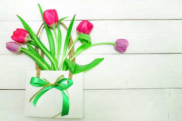 Bunch of red and purple tulips on white wooden background with copy space like postcard on womens day