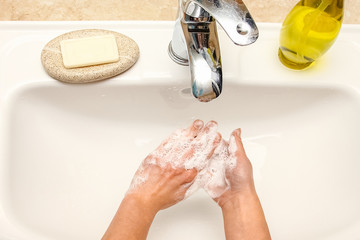 A Washing hands with soap under the faucet with water