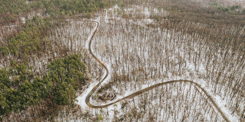 Banner winding road through the winter forest. Drone photo Winter forest landscape.