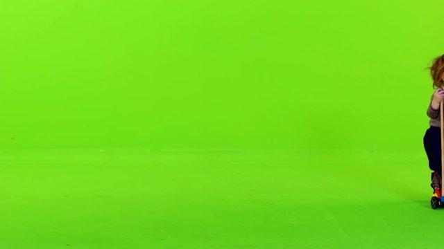 Cute little toddler running from side to side, happy, holding a toy, full shot over green screen.