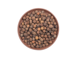 Spice allspice in clay plate isolated on white. Indian cuisine, ayurveda, naturopathy concept