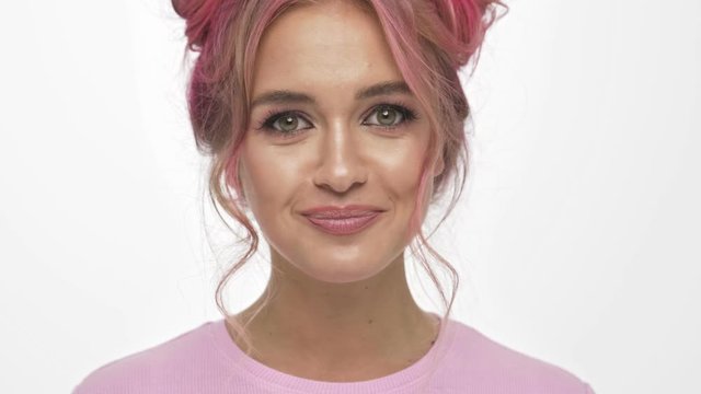 A close-up view of attractive young girl inflates a gum white background