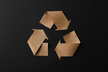 Recycling sign on black background, top view