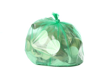 Green disposable bag with different trash isolated on white background