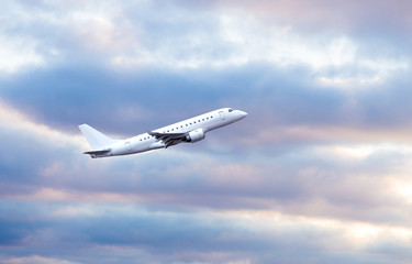 Fototapeta na wymiar white jet aircraft in flight on cloudy sky background.