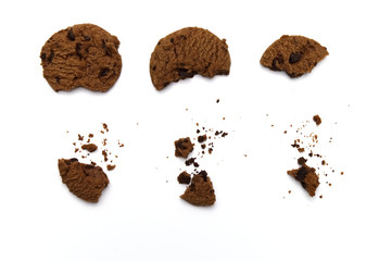 Chocolate chip cookies with some broken and crumbs on white background in Top view.