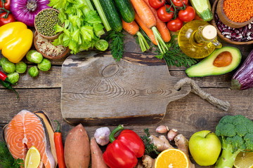 Healthy food background. Fresh vegetables, fruits, beans, meat and fish on wooden table. Healthy balanced food, dieting and healthy eating concept. Top view