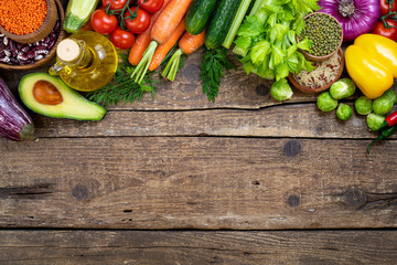 Healthy food background. Fresh vegetables, fruits, beans and lentils on wooden table. Vegetarian and vegan food. Healthy eating concept. Copy space