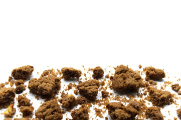 Scattered crumbs of chocolate chip cookies on white background and copy space.