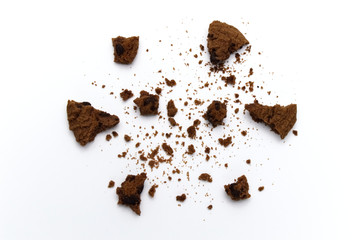 Scattered crumbs of chocolate chip cookies on white background.