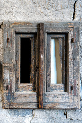 alter hölzener Fensterrahmen ohne Glas in einer Mauer eingelassen