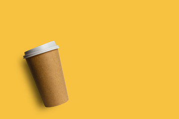 Simply flat lay design brown paper coffee cup isolated on yellow pastel colorful background