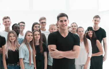 confident guy standing in front of a casual group of young people.