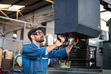 Young engineers are doing practical on the job training on how to use a controller for a factory by computer.