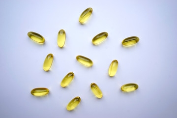 Omega yellow capsules on the white background