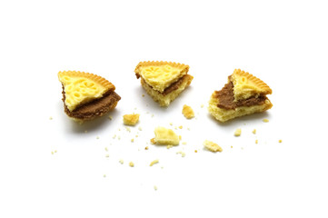 Sandwich cookies filled with coffee cream flavored. Some broken and crumbs of crunchy delicious sweet meal and useful cookie on white background.