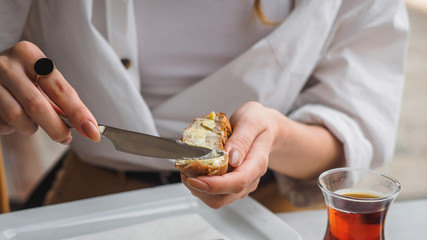 Woman spreads butter on bread. Hands with knife