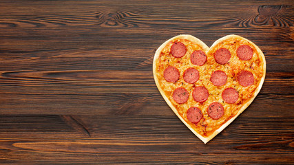 Fototapeta na wymiar Lovely arrangement for valentines day dinner with heart shaped pizza and copy space