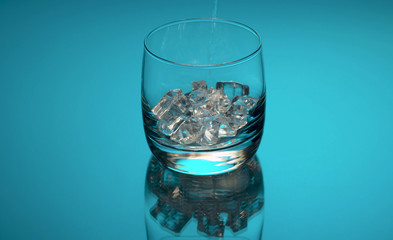 Water pouring into a glass with ice