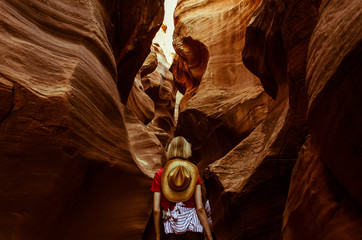 Dziewczyna przechodzi przez  kanion w Antelope Canyon, Arizona, USA - obrazy, fototapety, plakaty