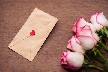 Soft Romantic Rose Wallpaper. Pink rose bouquet with a love letter on vintage wooden surface. Background for anniversary, wedding, birthday card, invitation, cover, pamphlet.