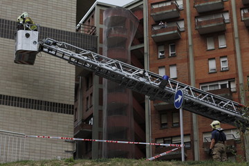 Firefighters checking a damaged facade on a crane