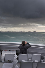 Photographing Skyline Auckland New Zealand. Dark clouds. Ferry to the city from Waiheke island