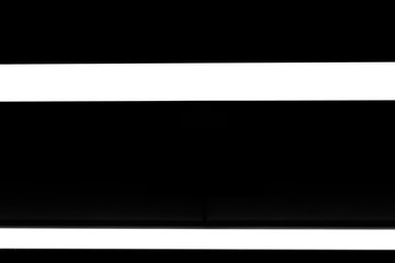 Obraz premium Two modern white neon wall or ceiling lamps in the form of a long stripe in a dark room. Horizontal abstract geometric shape and line on a black background