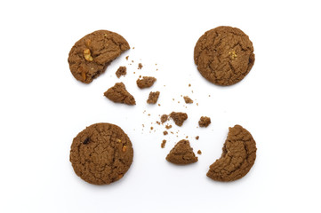 Cookies with chocolate chip flavored. Some broken and crumbs of crunchy delicious sweet meal and useful biscuits on white background.