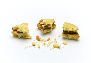 Sandwich cookies filled with coffee cream flavored. Some broken and crumbs of crunchy delicious sweet meal and useful cookie on white background.