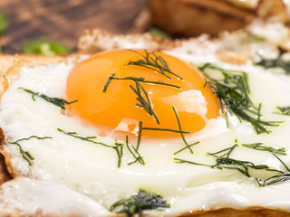 fried eggs with bread toast on wooden background