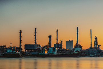 Fototapeta na wymiar Oil and gas refinery industry plant with glitter lighting and sunrise in the morning, Factory of petroleum industrial, Per plant,Energy power station area. Industry