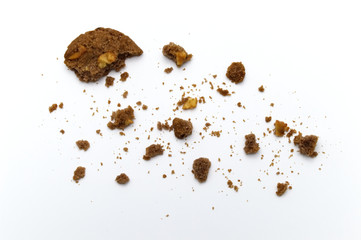 Cookies of chocolate chip butter flavored bitten with scattered crumbs on white background.