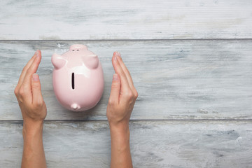 woman hand putting money coin into piggy for saving money wealth and financial concept