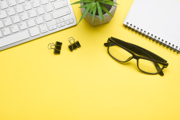 Yellow desk office with laptop, smartphone and other work supplies with cup of coffee. Top view with copy space for input the text. Designer workspace on desk table essential elements on flat lay